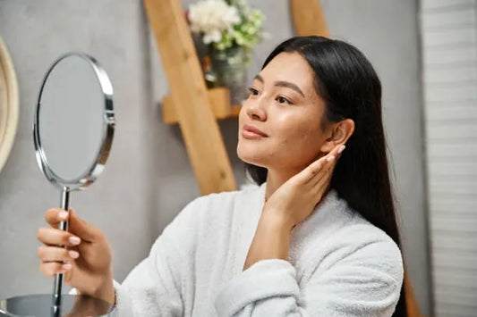 Woman examining pores and skin texture before microneedling.