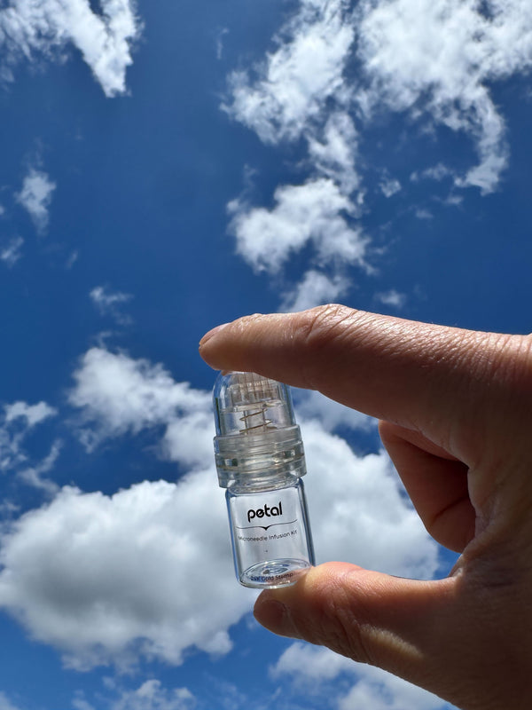 image of hand holding Petal microneedling system in the sky
