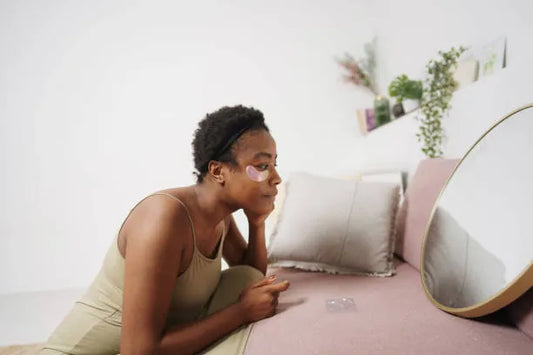 Woman applying eye patches for dark circles and tired eyes.