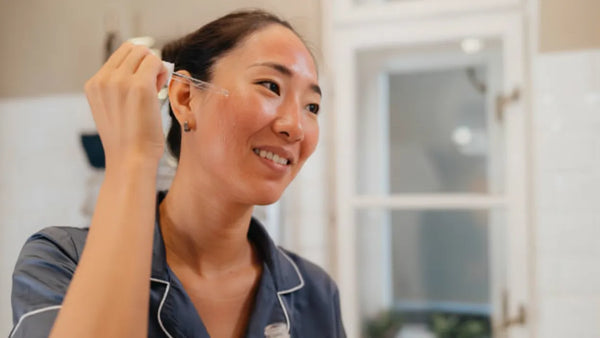 Woman applying soothing serum after microneedling treatment