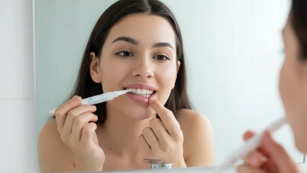 Woman using a whitening pen as part of an at-home whitening routine