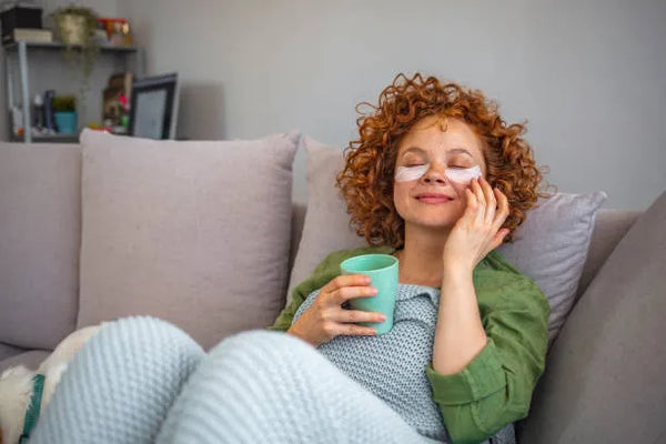woman applying eye patches to reduce puffiness in morning skincare routine