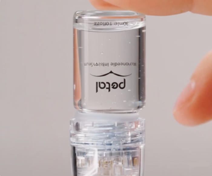 Prime the microneedle stamp by ensuring the serum flows smoothly into the microneedle chamber.